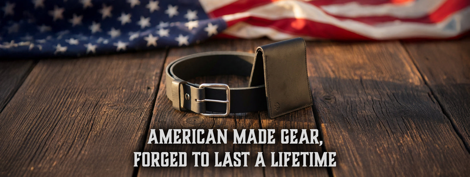 Main Street Forge leather belt and bifold wallet on weathered wood in front of an American flag. American made gear, forged to last a lifetime.